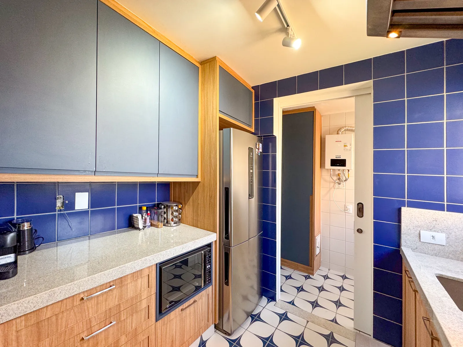 Cozinha com revestimento azul e armários em madeira